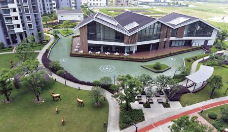 A residential area at LifeHub@Kunshan includes heavily landscaped grounds and a resilient-surface running track, in orange.