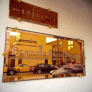 The street reflected in a stained-glass manufacturer’s sign. (Sean Slater)