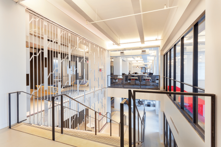 Shutterstock’s Empire State Building offices feature a wide stairway that connects workplaces and provides room for workers to have impromptu conversations. The expansive workspace also is optimized for energy efficiency. (© Empire State Realty Trust Inc.)