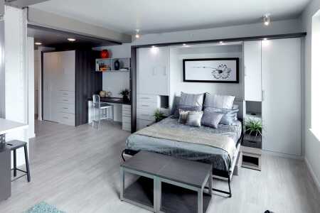 The increased development of urban micro-unit apartments is leading to some innovative design features intended to make small living spaces more flexible and multi-dimensional. Urbaneer has developed a product that combines storage cabinets, a pull-down Murphy bed, and a couch. The Murphy bed can fold out of the cabinet right over the couch, allowing one room to serve as a living space by day and a bedroom at night. (Urbaneer)