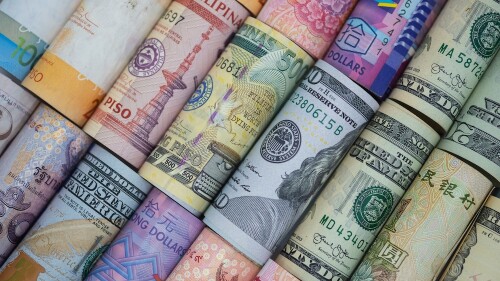 Closeup rolled of variety banknote around the world. Exchange rate and Forex investment concept.-Image.