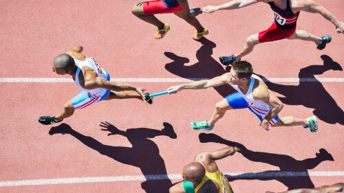 Relay,Runners,Passing,Batons,On,Track