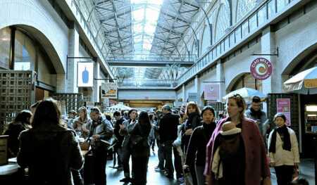 Throngs of visitors and locals peruse the marketlike tenants along the skylit arcade in the Ferry Building in San Francisco. (Sean Slater)