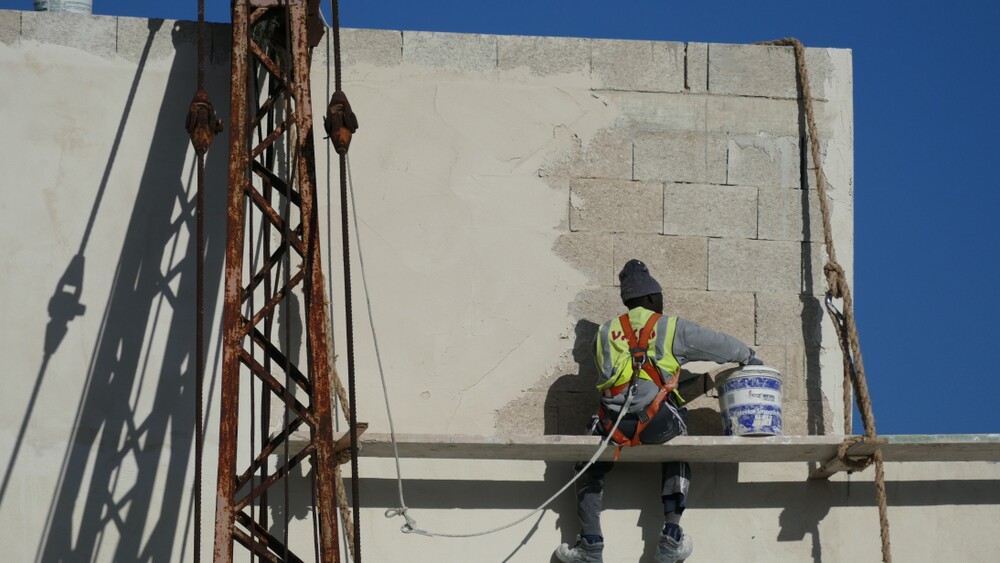 Unidentified,African,Refugee,Illegally,Painting,The,Façade,Of,A,Factory