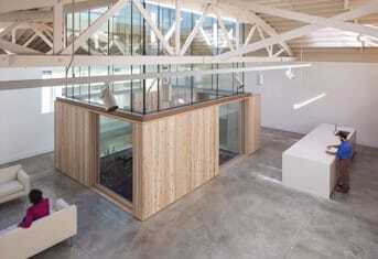 In the Bowstring Truss House, the whole box of the atrium above the 8-foot-tall (2.4 m) wooden box is glazed to the top chord of the bowstring trusses, acting as a giant light scoop to flood the interior with daylight. (Joshua Jay Elliott)