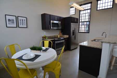 The former prison dormitories, now a mix of market-rate and affordable apartments, include high-end urban finishes of exposed brick, maple cabinetry and granite countertops. (The Alexander Company)