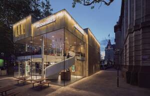 A minimalist one-piece cantilevered white steel spiral staircase is recessed behind and encased in a glazed corner that opens the views toward the post office and to the corner. (JeroenMusch)