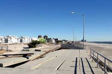 The boardwalk dune preserve the day after Sandy. It took the initial hit of the Sandy storm surge and dissipated its energy as the water moved inland. The sloped roofs and angled orientation of the two-family residential homes are in the background. (© Peter David Cavaluzzi FAIA-Perkins Eastman)